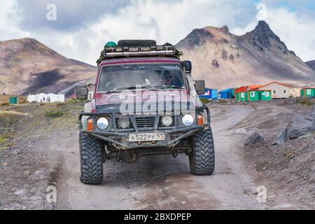 Véhicule utilitaire sport japonais Nissan Patrol conduite sur route rocheuse sur fond de paysage volcanique. Voyage tout-terrain, aventure en voyage Banque D'Images