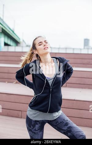 Jeune femme de sport souffrant de douleurs dorsales après l'entraînement Banque D'Images