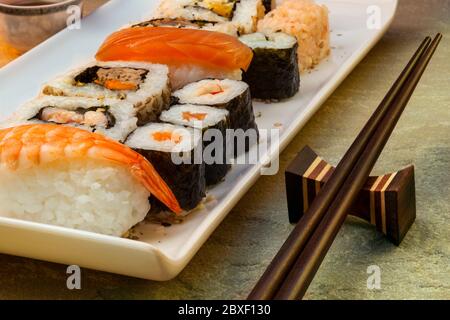 Le sushi est un plat japonais composé de petites boules ou de petits rouleaux de riz froid au vinaigre, servis avec une garniture de légumes, d'œufs ou de fruits de mer crus. Banque D'Images