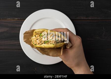 Dans la main de Rou jia Mo, ce hamburger chinois est une cuisine populaire de rue. Sur une photo, un sandwich dans un emballage papier. Vue de dessus. Copier l'espace. Pose à plat. Banque D'Images