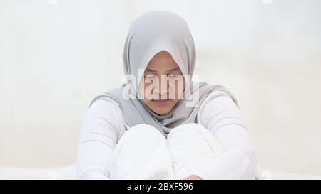 Triste femme musulmane portant le hijab pleurant dans la douleur, se sentant solitaire, concept de dépression Banque D'Images