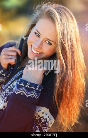 Portrait de jeune femme souriante dans des couleurs chaudes de coucher de soleil . Lumière de fin d'été Banque D'Images