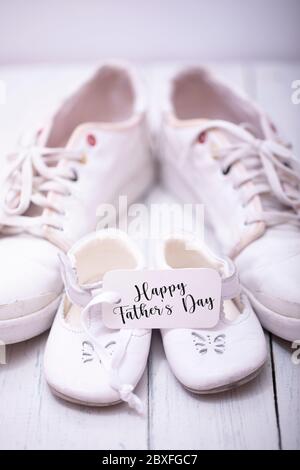 Chaussures pour hommes et enfants sur fond de bois blanc. Concept de fête des pères heureux. Banque D'Images