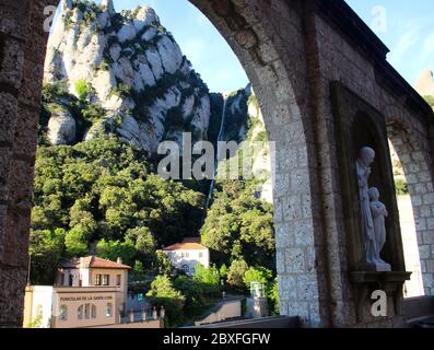 Funiculaire de la Santa Cova Montserrat monastère bénédictin Dawn Strong Lumière du soleil et ombres profondes vues à travers des arches avec des statues de Catalunya Espagne Banque D'Images