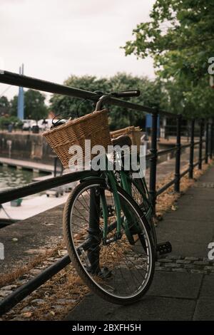 Une moto traditionnelle avec des paniers inclinés contre les rails Banque D'Images