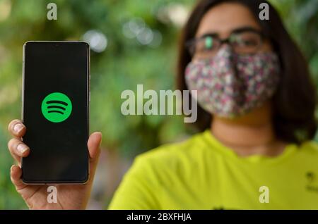 New York, États-Unis, 2020. Fille portant un masque et affichant l'icône de l'application Spotify sur l'écran du téléphone mobile. L'abonnement à Spotify a augmenté pendant Co Banque D'Images