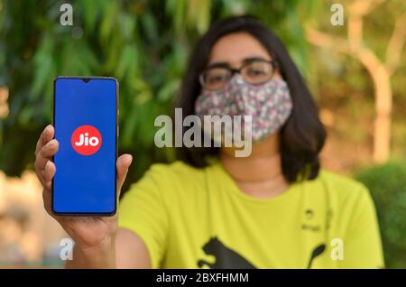 Mumbai, Inde, 2020. Fille portant un masque facial montrant la page d'accueil de Reliance Jio sur son écran mobile pendant la pandémie du virus Corona (Covid-19). Internet u Banque D'Images