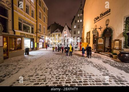 TALLINN, ESTONIE - 4 JANVIER 2017 : vue nocturne sur les rues de la vieille ville de Tallinn en hiver. La neige, les gens, les restaurants et les magasins sont visibles. Banque D'Images