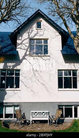 Deux chaises de jardin pliantes et un banc en bois blanc, devant la façade de la maison à Reykjavik, la capitale de l'Islande. Banque D'Images