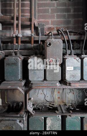 Vieux boîtiers de commande électrique en métal d'époque sur un vieux mur dans le complexe industriel Zollverein à Essen, Allemagne Banque D'Images