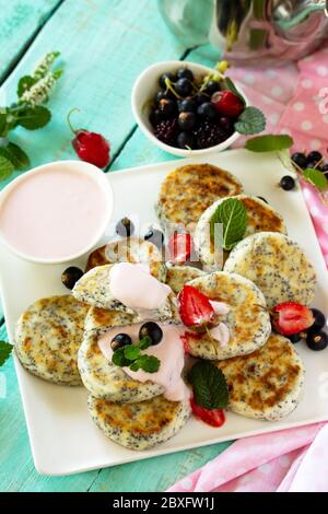 Petit déjeuner d'été. Crêpes maison au fromage cottage avec graines de pavot, sauce à la crème aigre avec fraises. Banque D'Images