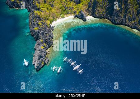 Vue aérienne des bateaux de plongée blancs sur place, à proximité de l'île tropicale de Miniloc. El Nido, île de Palawan, Philippines Banque D'Images