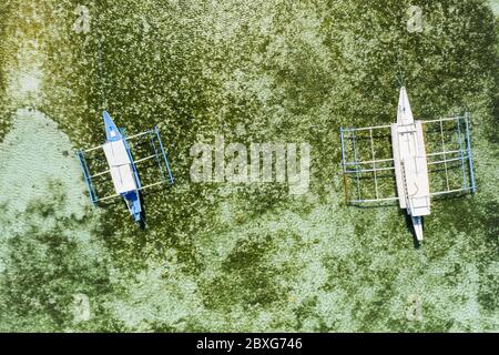 Vue aérienne de haut en bas d'un deux bateaux de tourisme sur un récif tropical de corail dans un océan clair Banque D'Images