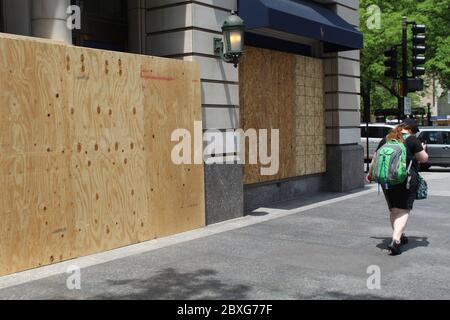 Femme avec un sac à dos qui marche devant un magasin à bord de North Michigan Avenue à Chicago après une émeute Banque D'Images