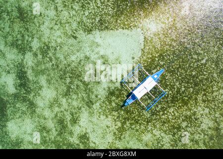 Vue aérienne d'un bateau touristique sur un récif de corail tropical dans un océan clair Banque D'Images