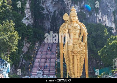 KUALA LUMPUR, MALAISIE - 7 AVRIL 2017 : l'extérieur des grottes de Batu et l'immense déité hindoue du Seigneur Murugan. Beaucoup de gens peuvent être vus sur les escaliers Banque D'Images