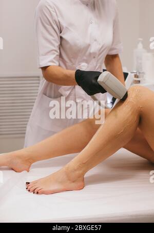 Femme ayant un traitement d'épilation au laser dans un salon de beauté Banque D'Images