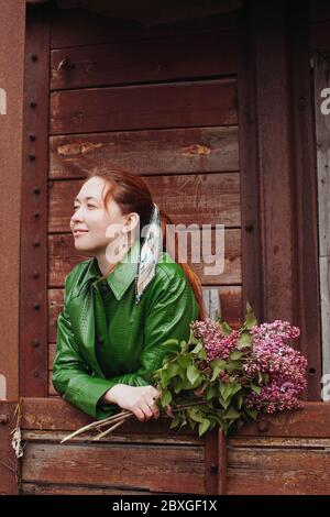 Femme debout à l'extérieur tenant des fleurs fraîchement cueillies, Russie Banque D'Images