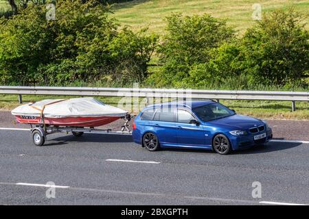 2006 bleu BMW 320D M Sport Touring bateau de remorquage sur remorque; véhicules de circulation automobile, voitures de plaisance conduite de véhicule sur les routes du Royaume-Uni, moteurs, loisir moto sur l'autoroute M6 Banque D'Images