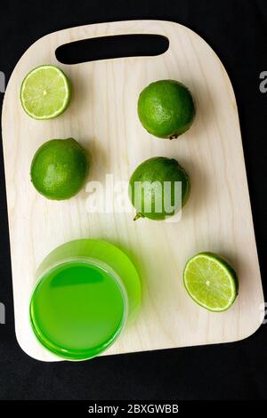 Verres de limonade avec chaux, planche en bois sur fond noir. Vue de dessus avec espace de copie Banque D'Images