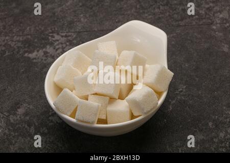 Petits morceaux de sucre blanc raffiné en granulés dans le bol Banque D'Images