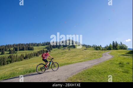 Jolie femme âgée à cheval sur son vélo électrique de montagne sur les montagnes au-dessus d'Oberstaufen, Allgau Alpes, Bavière Allemagne Banque D'Images