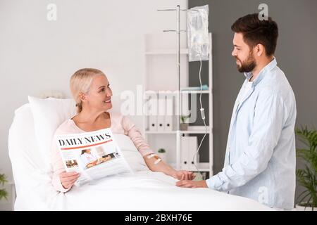 Homme rendant visite à sa mère à l'hôpital Banque D'Images