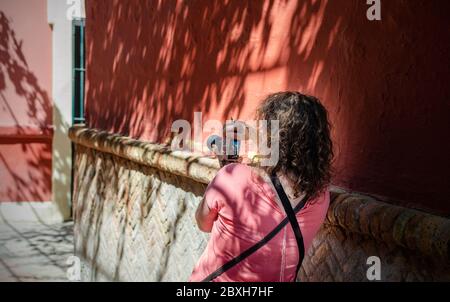 Femme caucasienne prenant des photos sur une rue touristique de Séville, Espagne après le verrouillage du coronavirus Banque D'Images