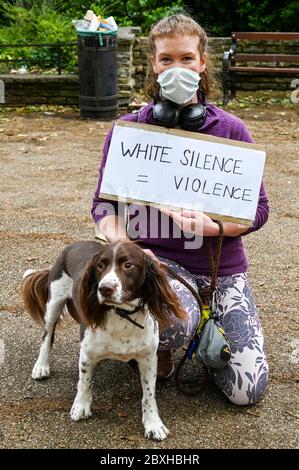 Une jeune femme blanche dans un masque avec un chien et un écriteau, 'White silence = violence' lors d'une manifestation en faveur de 'Black Lives Matter'. Londres, Royaume-Uni. Banque D'Images