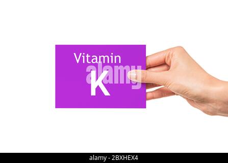 La main féminine montre une carte avec l'inscription vitamine K. vitamine K. Banque D'Images