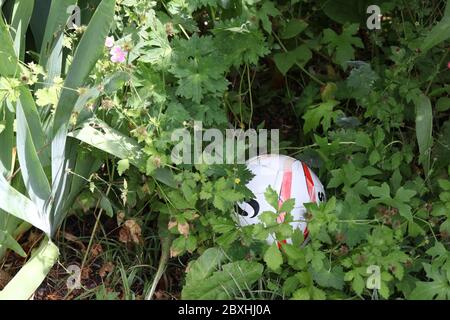 Football ou ballon de football perdu dans le jardin, Royaume-Uni Banque D'Images