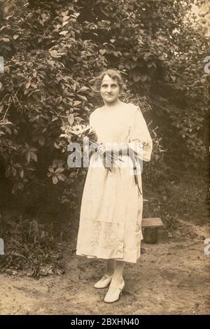 Lettonie - VERS les années 1920 : photo du corps entier. Jeunes femmes dans le jardin. Carte de vue d'époque édouardienne Banque D'Images