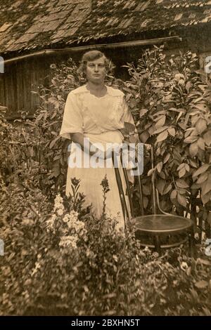 Lettonie - VERS les années 1920 : photo du corps entier. Jeunes femmes dans le jardin. Carte de vue d'époque édouardienne Banque D'Images