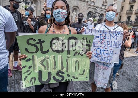 Un manifestant tient un écriteau qui indique que cessez de nous tuer pendant la manifestation.à la suite de la mort de George Floyd alors qu'il était détenu par la police de Minneapolis, au Minnesota, des milliers de personnes manifestent à Barcelone contre le racisme. Banque D'Images