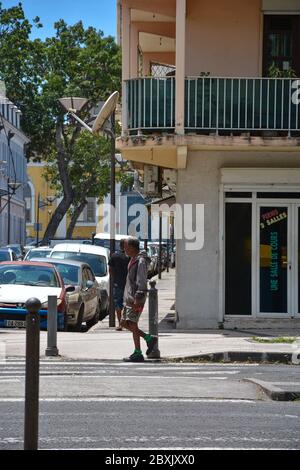 Point-a-Pitre, Guadeloupe - 17 septembre 2018 : un homme sans domicile vêt de vêtements sales à la tête grise descend dans la rue dans un chandail, un short, une basket Banque D'Images