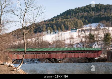 Pont couvert de Taftsville, situé à Woodstock, Vermont, en hiver, avec de la neige sur la montagne en arrière-plan. Banque D'Images