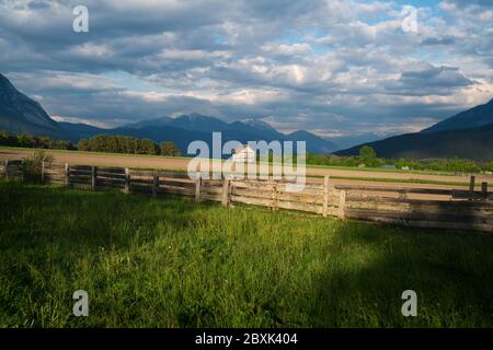 Coucher de soleil sur la campagne alpine en été avec clôture et grange, et paysage nuageux spectaculaire plateau Mieminger, Tyrol, Autriche Banque D'Images