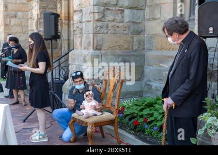 Detroit, Michigan, États-Unis. 7 juin 2020. L'archevêque catholique de Detroit Allen Vigneron (à droite) a dirigé un rosaire pour la justice raciale à l'extérieur de Sainte-Anne Basilique Anne. Tenue par son père Bernardo Conteras, Julietta Contreras, 10 mois, a eu l'occasion de s'asseoir sur la chaise de l'archevêque pendant que sa mère Janet Contreras a lu le second mystère. L'événement a eu lieu après deux semaines de protestations au sujet du meurtre par la police de George Floyd à Minneapolis. Les paroissiens présents ont été invités à pratiquer la distanciation sociale et à porter des masques en raison de la pandémie du coronavirus. Crédit : Jim West/Alay Live News Banque D'Images