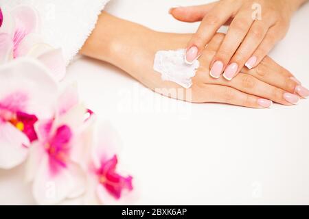 Femme applique la crème hydratante pour les soins de la peau des mains Banque D'Images