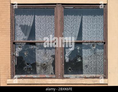 Fenêtres cassées avec rideaux en dentelle. Image prise à l'ancienne usine de dentelle de Scranton, construite en 1890, fermée en 2002, démolie en 2019. Banque D'Images