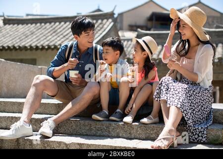 Une bonne famille chinoise qui mange de la crème glacée à l'extérieur Banque D'Images