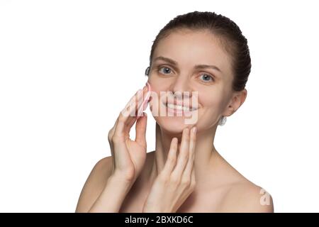 Belle jeune femme modèle souriant et peeling visage et nez avec pinceau en silicone rose cosmétique sur fond blanc Banque D'Images