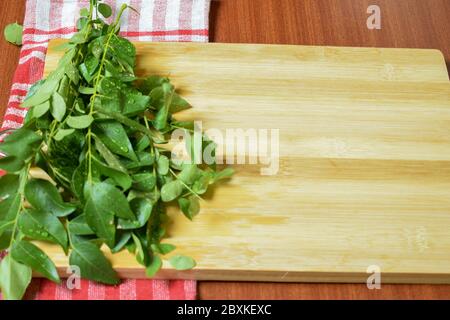 Bouquet de feuilles de curry indien fraîches / feuille de curry sur fond de bois Banque D'Images