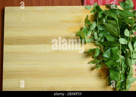 Bouquet de feuilles de curry indien fraîches / feuille de curry sur fond de bois Banque D'Images