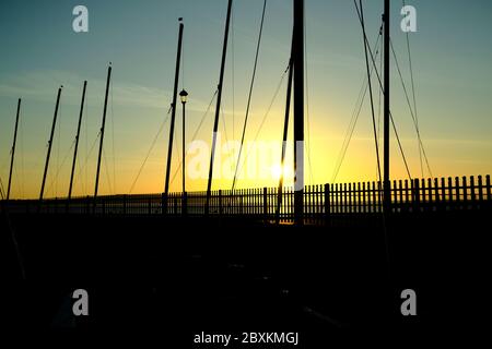 Mâts de yacht en silhouette au lever du soleil petite Hope Beach Shanklin Isle of Wight Royaume-Uni Banque D'Images