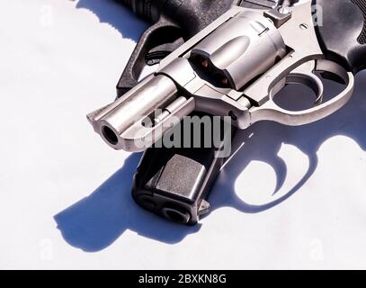 Deux pistolets, un revolver de 357 magnum sur un pistolet de 9 mm sur fond blanc Banque D'Images