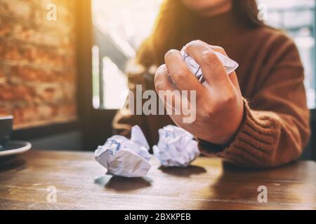 Une femme a vissé des papiers à la main sur une table en bois Banque D'Images