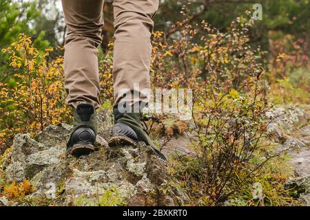 Bottes de randonnée sur le rocher. Pieds pour hommes en bottes sur pierres naturelles. Concept voyage et aventure Banque D'Images