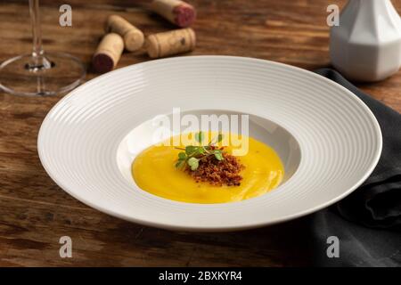 carotte, panais, crème de citrouille avec bacon sur plaque blanche en bois, bouchons en verre à vin Banque D'Images