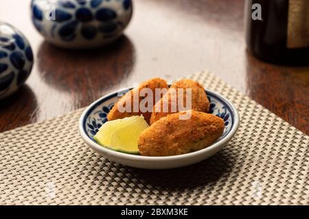 morue poisson frites boulettes de grignoter entrée portugais traditionnel bolinho de bacallahau sur table en bois et fond flou Banque D'Images